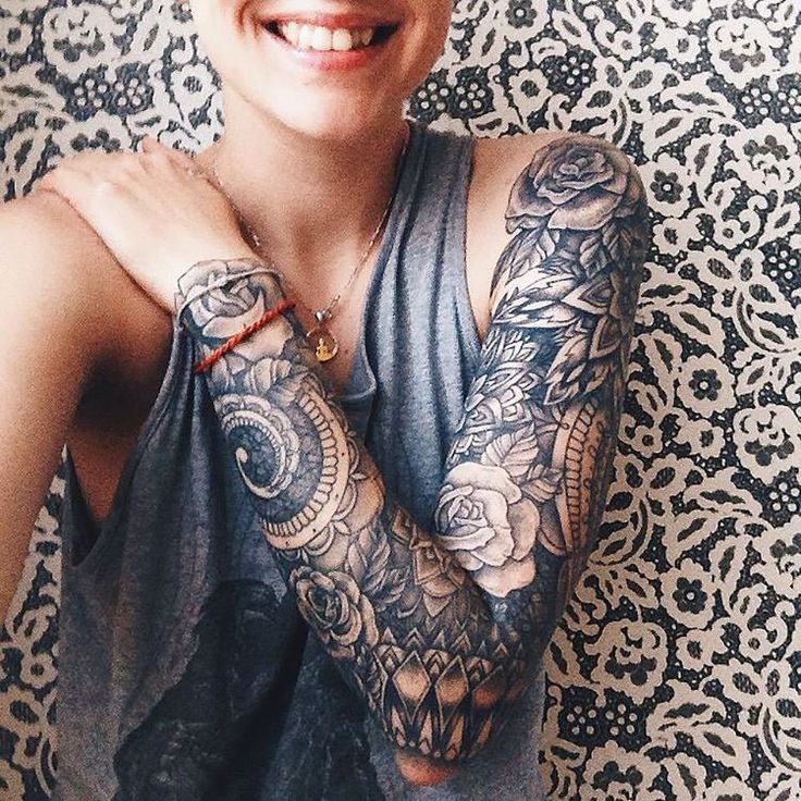 This full sleeve tattoo showcases a blend of mandala patterns and rose motifs, creating a striking visual impact.
