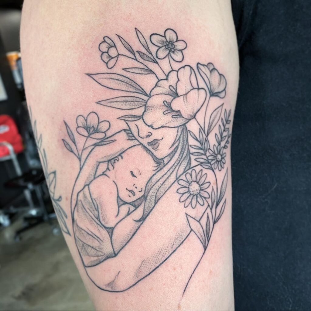 Mother Cradling Baby with Floral Surround Tattoo Tattoo Design