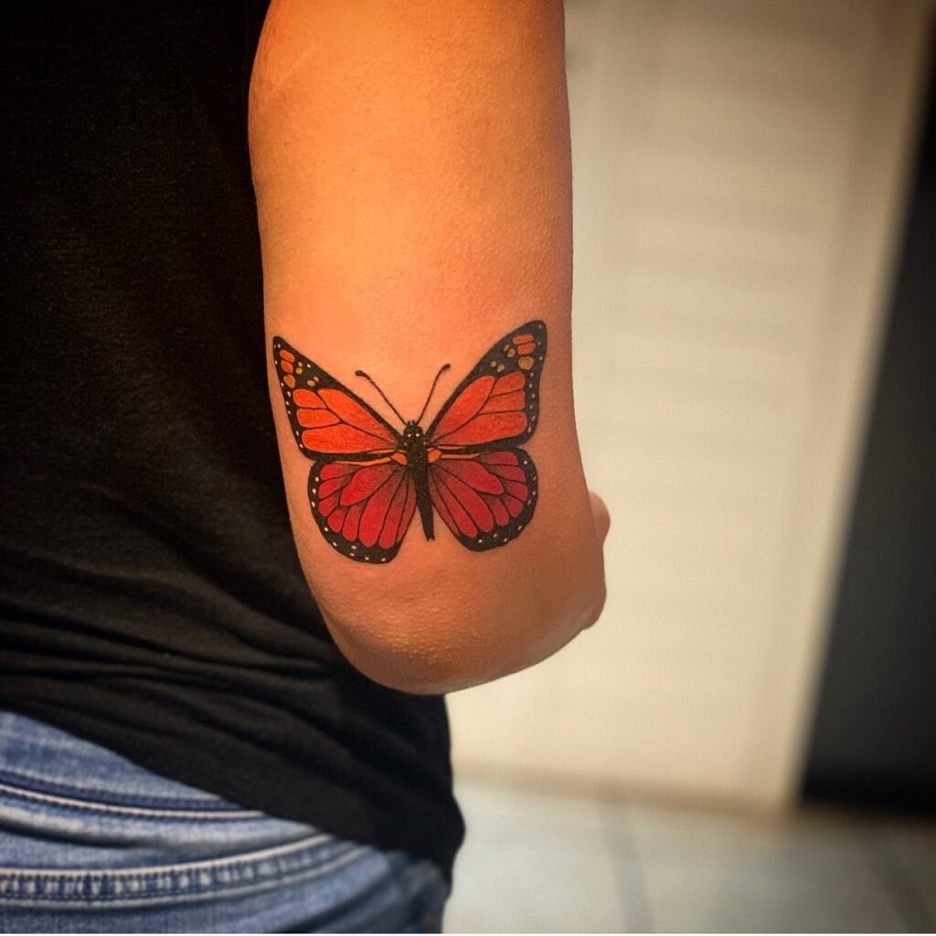 Red-Toned Monarch Butterfly Elbow Tattoo Tattoo Design