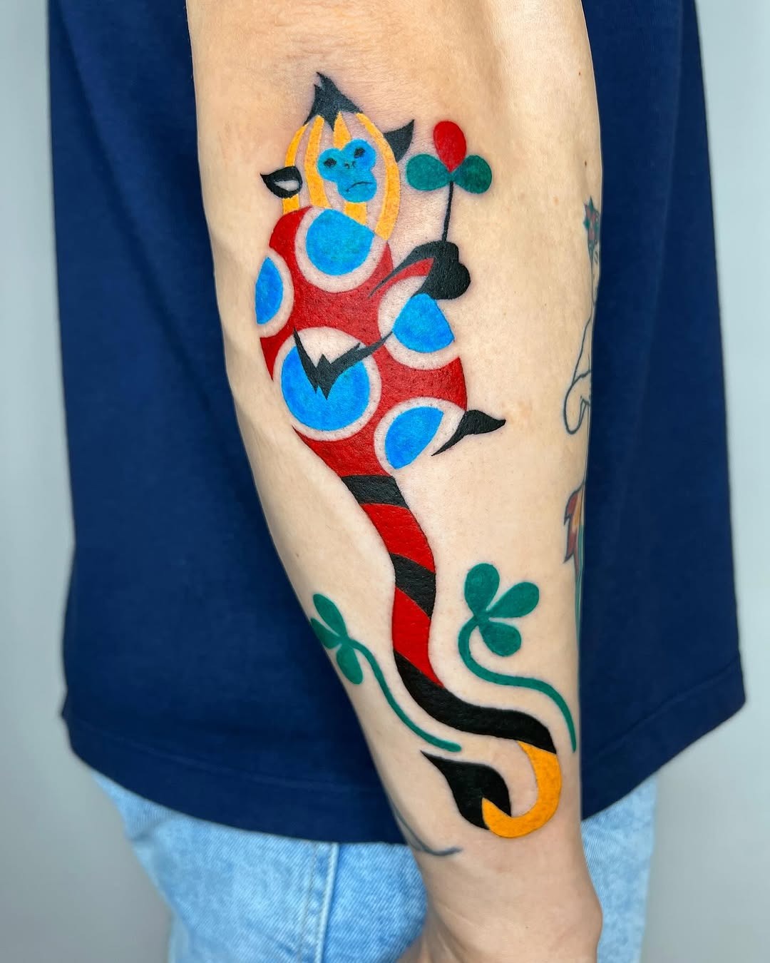 Playful monkey tattoo with vibrant colors and patterns Tattoo Design