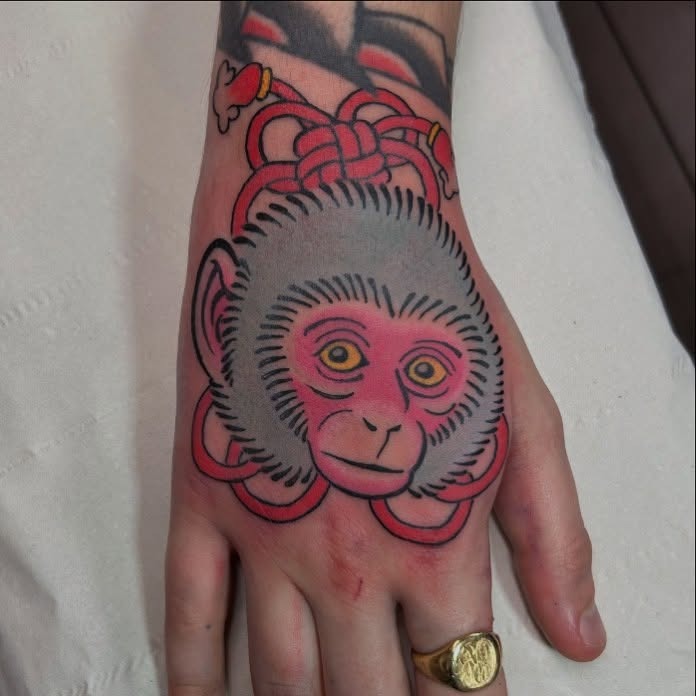 Vibrant Monkey Tattoo on Hand With Bold Colors Tattoo Design