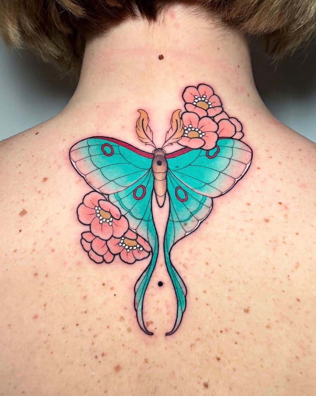 Colorful Moth Tattoo Blending with Flowers Tattoo Design