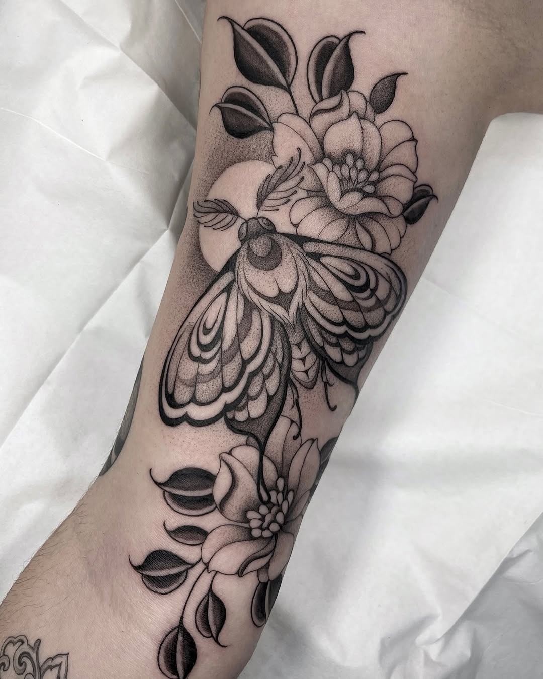 Elegant moth tattoo surrounded by blooming flowers Tattoo Design