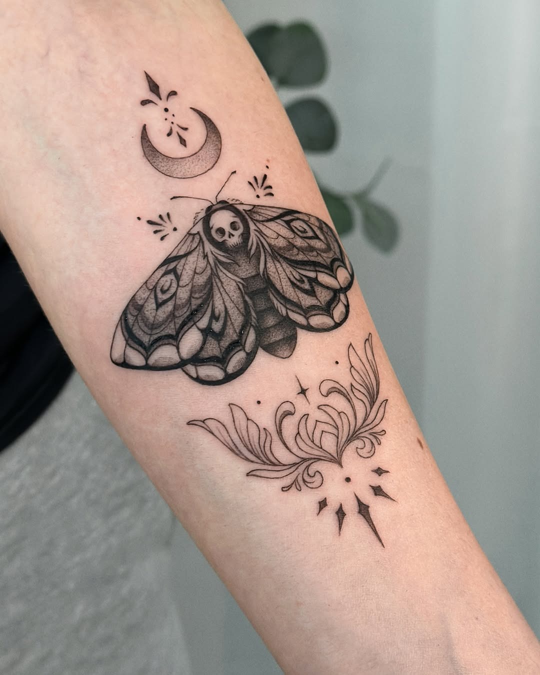 Intricate moth tattoo with moon and floral elements. Tattoo Design
