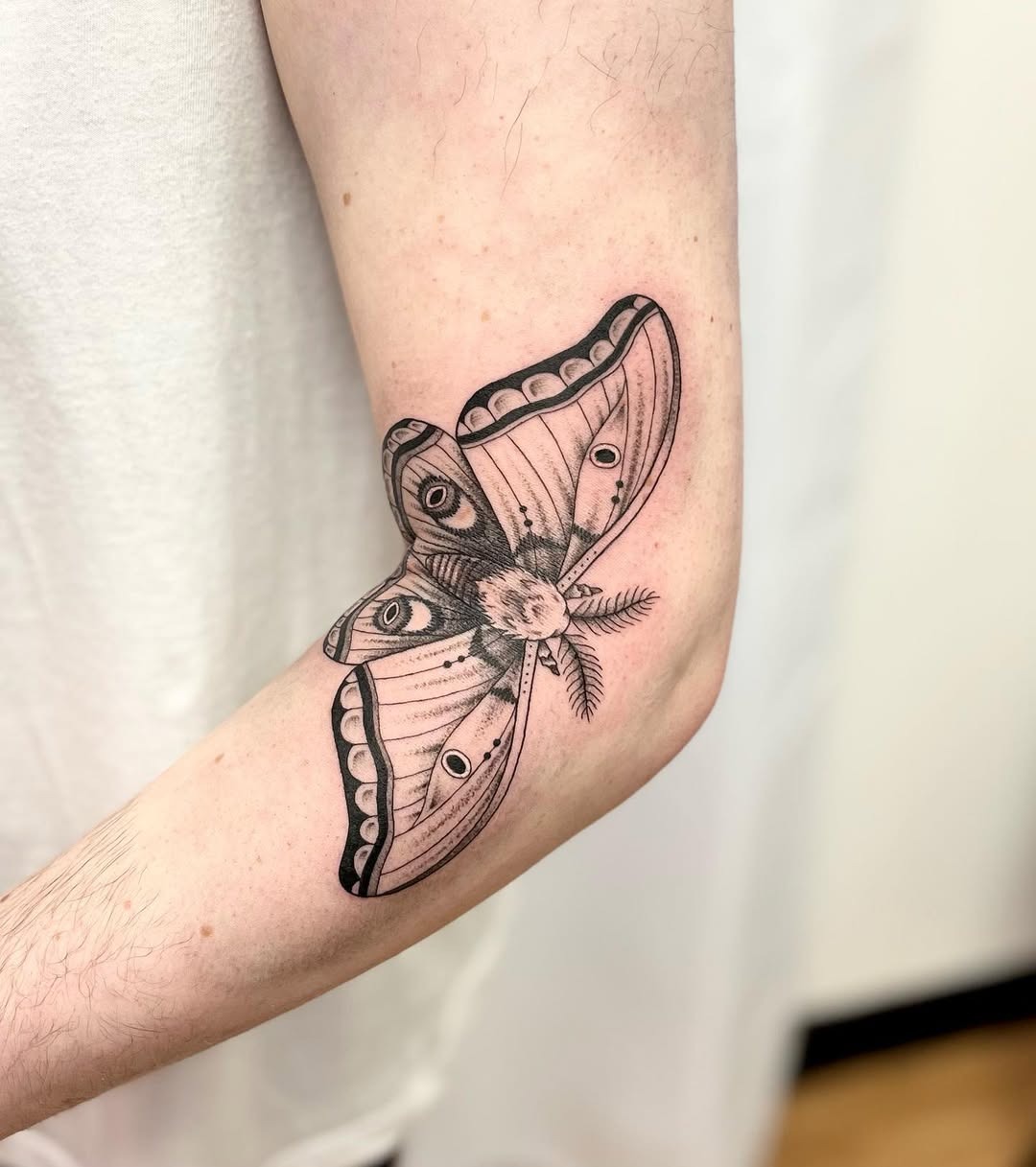 Stunning black and white moth tattoo on arm Tattoo Design