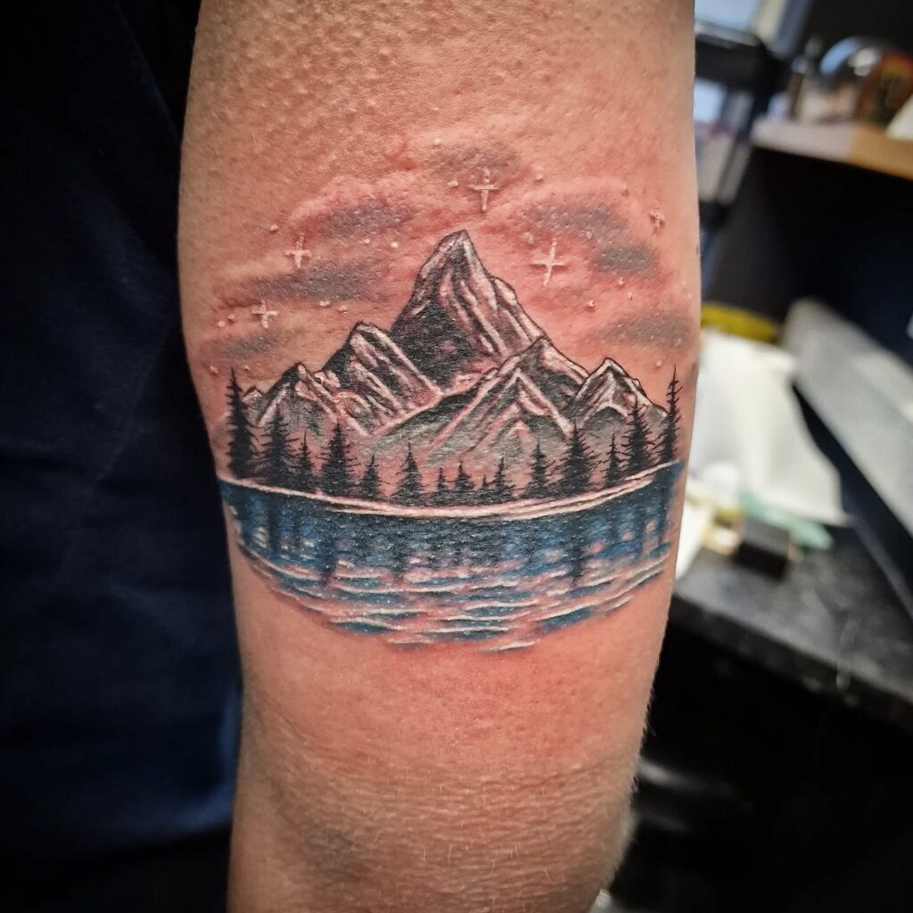 Mountain and Lake Nature Scene Tattoo on Back of Arm Tattoo Design