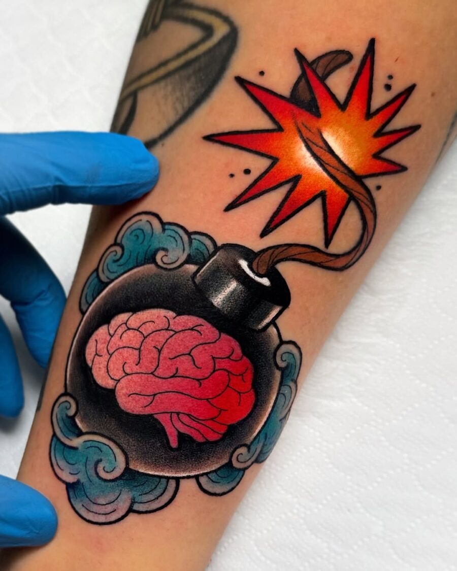 This tattoo features a unique bomb design with a brain, bursting with colors.