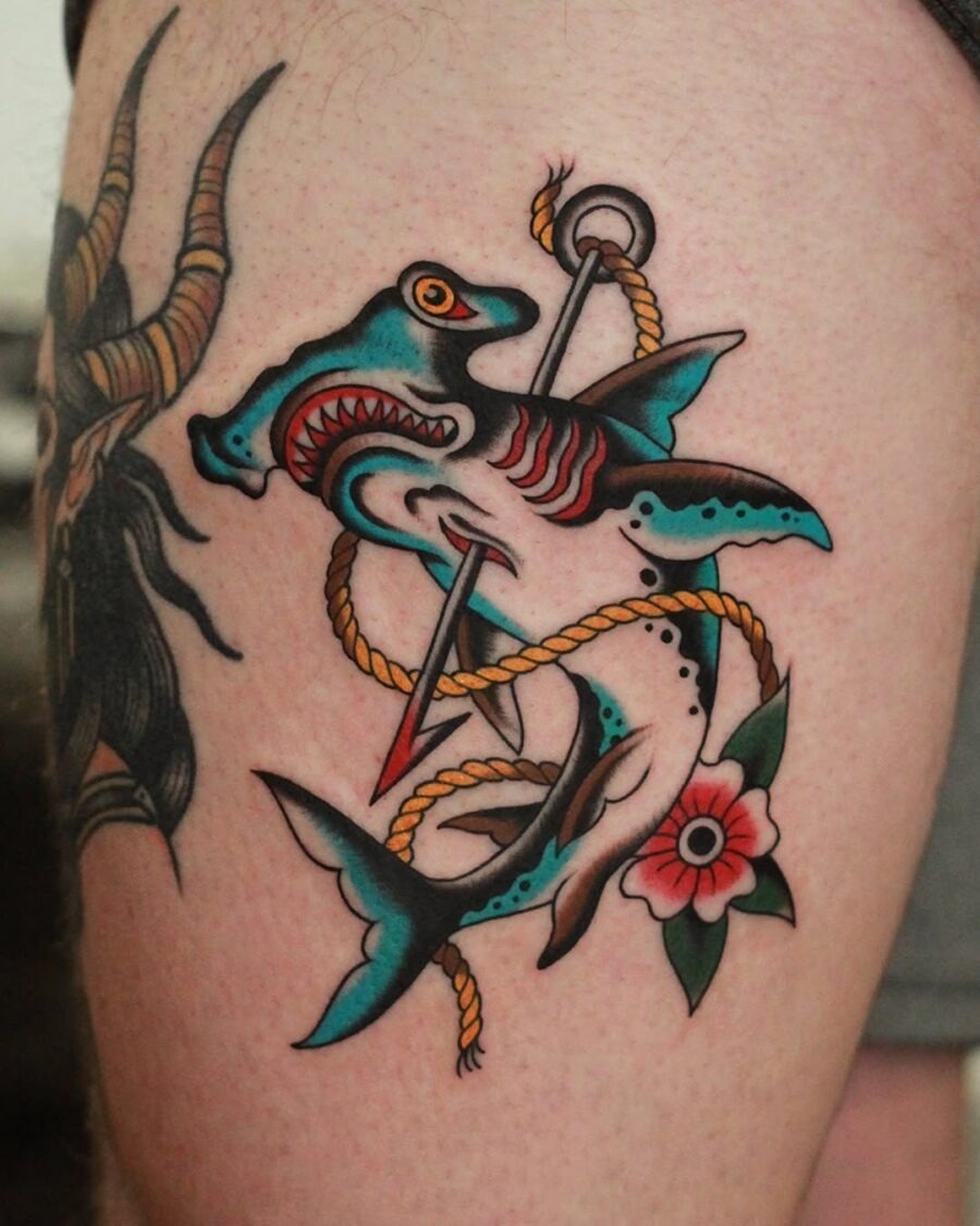 This striking shark tattoo features colors and bold lines, making it a standout piece.