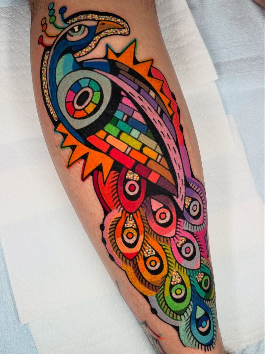 This tattoo showcases an eye-catching peacock rendered in colors.
