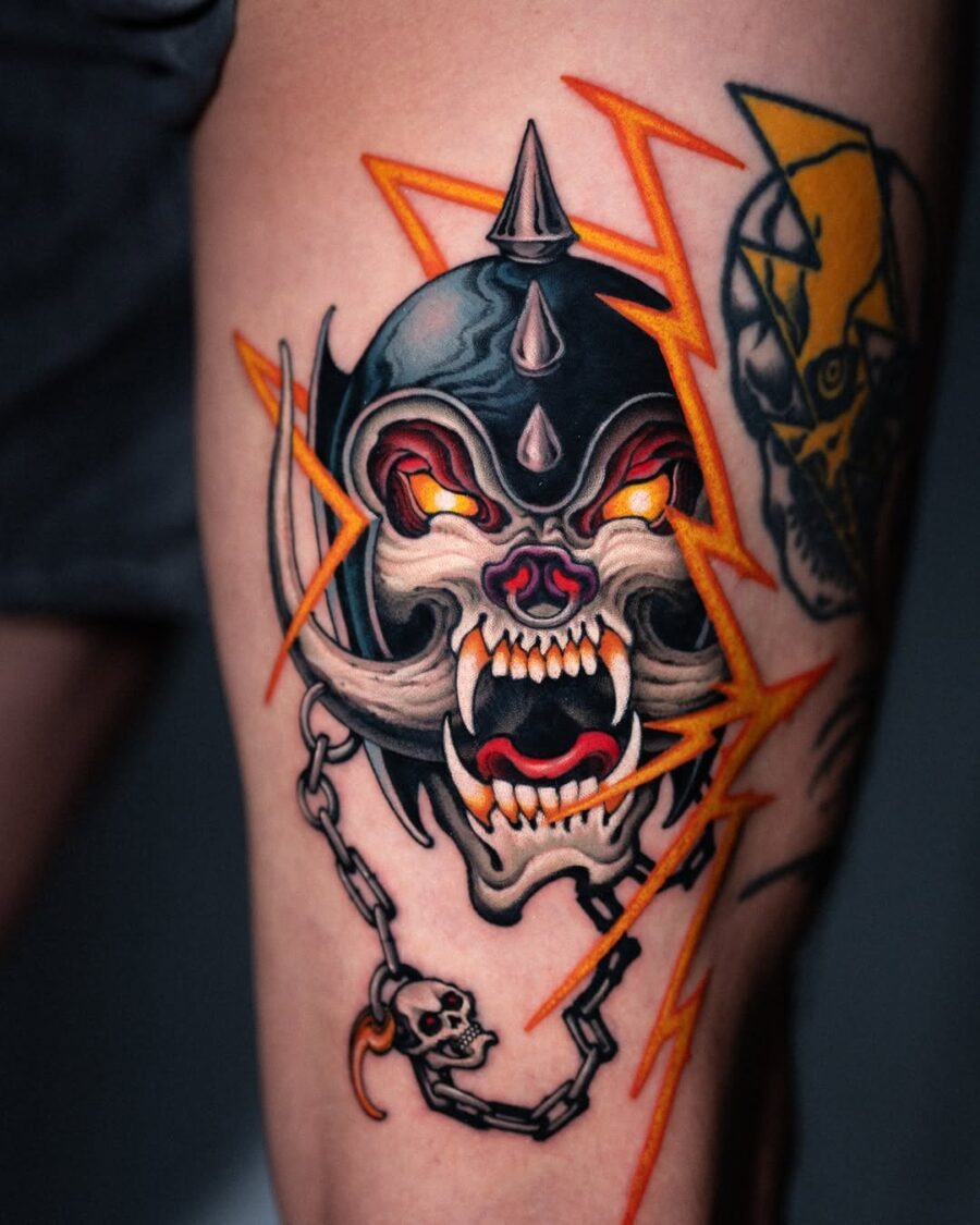 This striking tattoo features a fierce skull with glowing eyes, surrounded by jagged lightning bolts.