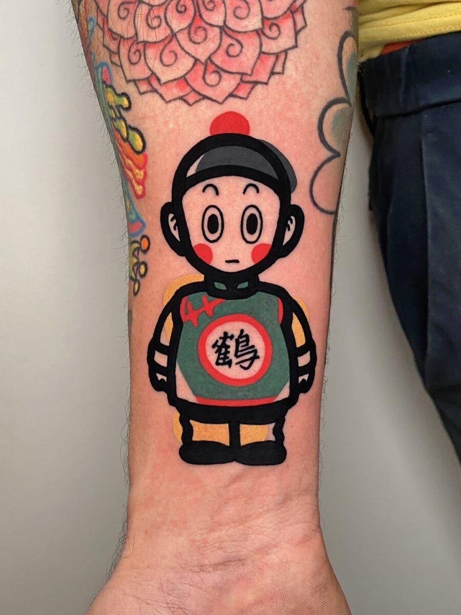 This tattoo features a playful cartoon character, showing a blend of traditional and contemporary art styles.