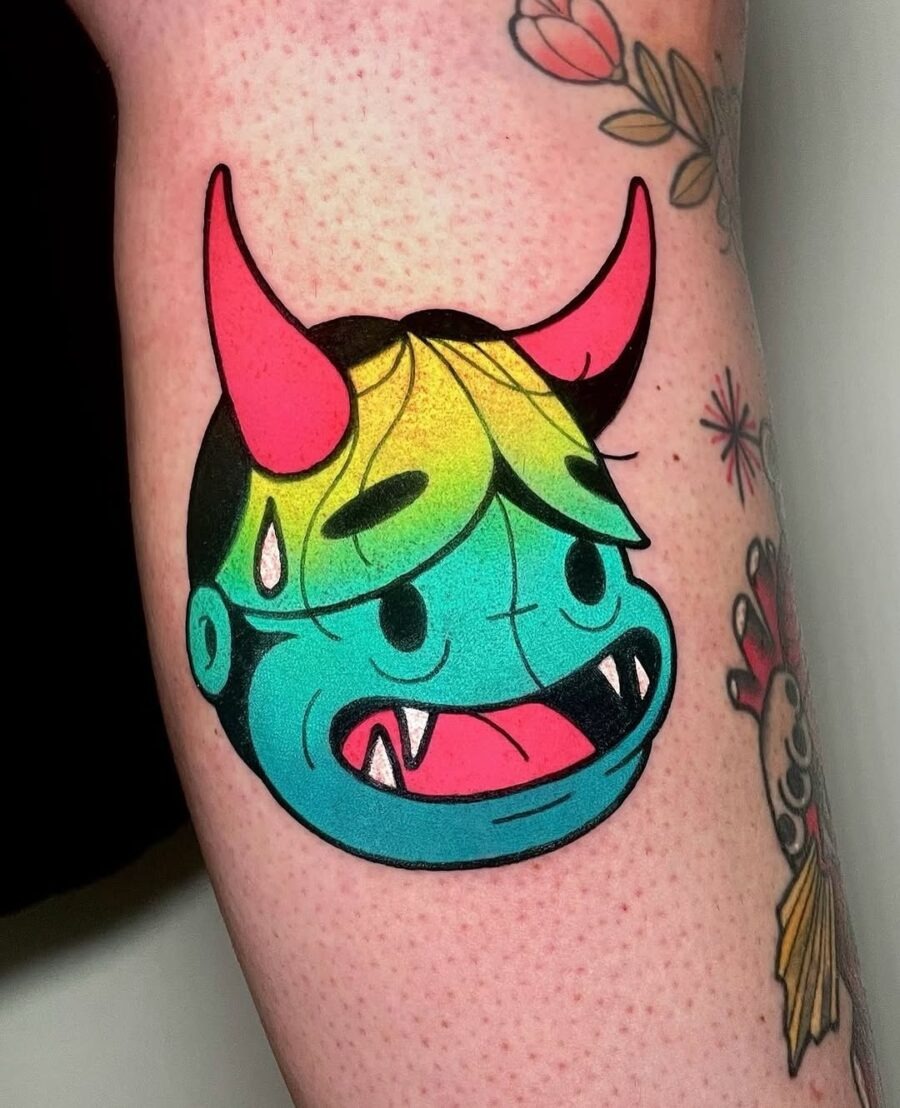 This tattoo features a vividly colored cartoon monster with a quirky expression.