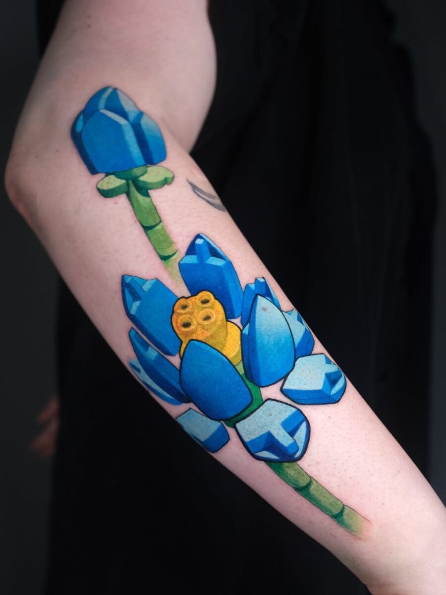 This tattoo features a stunning blue lotus flower with hues and intricate details.