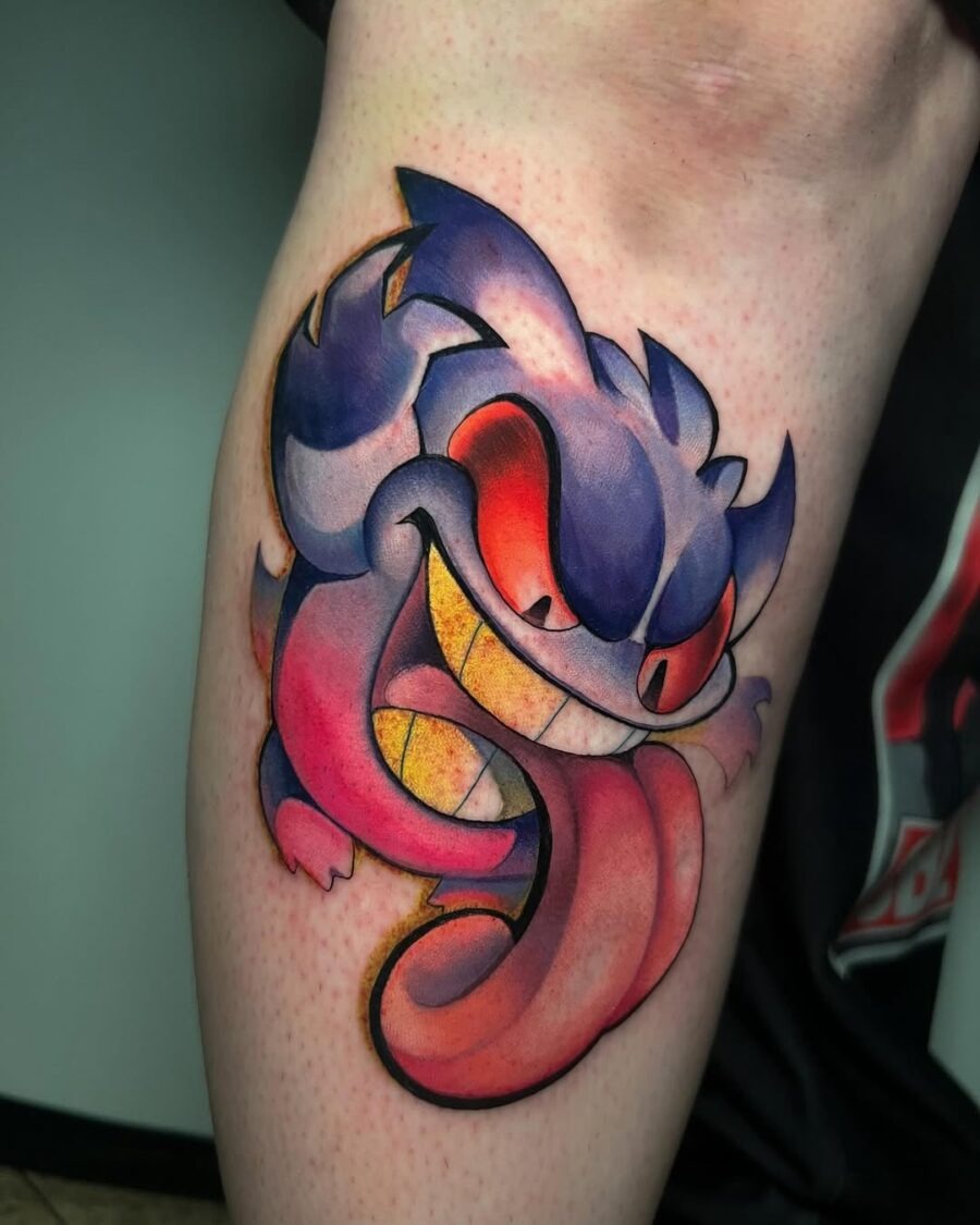 This tattoo features a playful monster motif with exaggerated features, colors, and a whimsical expression.