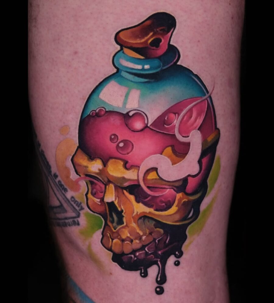This tattoo features a colorful skull encased in a vintage potion bottle, dripped with lively hues of pink and green.