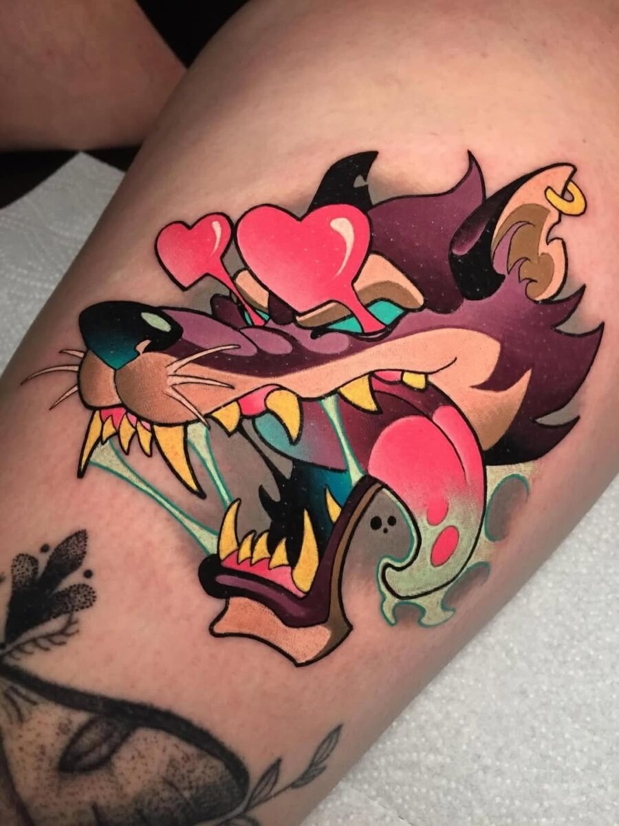 This colorful tattoo features a fierce wolf's head animated with exaggerated expressions and hues.