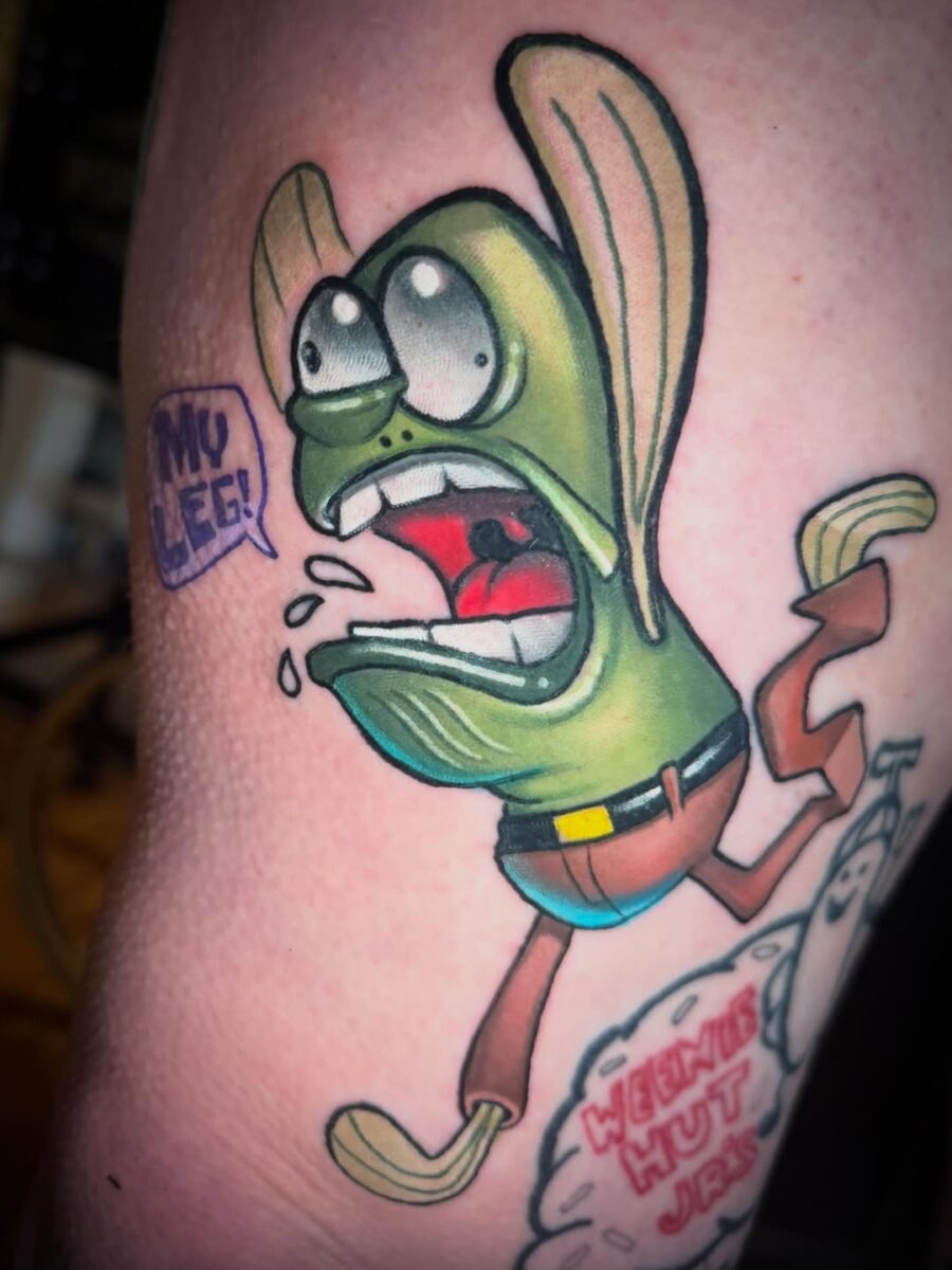 This lively tattoo features a cartoon character in a comical pose, capturing a moment of exaggerated expression.