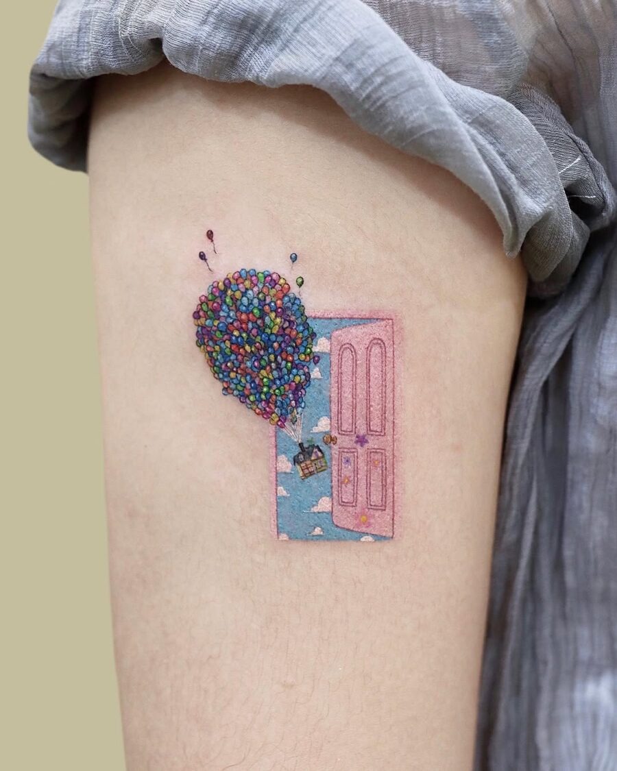 This enchanting tattoo features a door floating with balloons, creating an adventurous vibe.