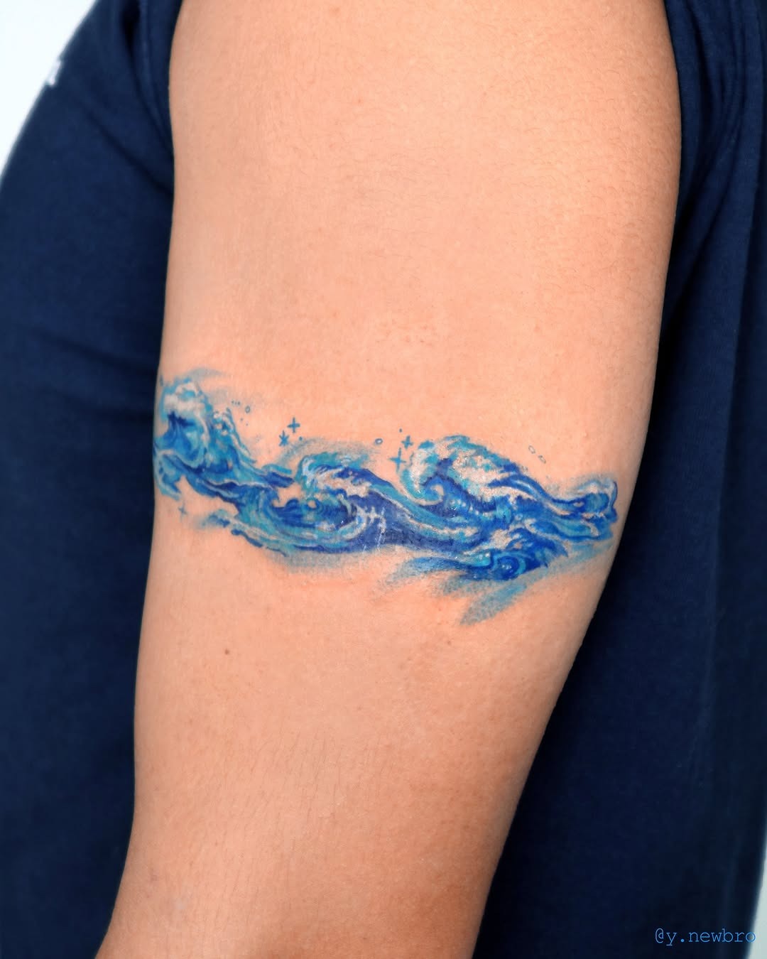 Vibrant ocean wave tattoo on upper arm Tattoo Design