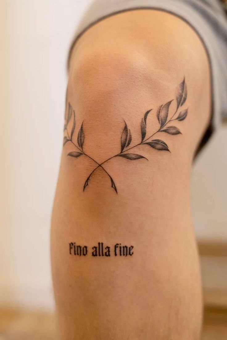 Crossed Olive Sprigs Above the Elbow, a tattoo design rendered in minimalist fine-line for the leg.