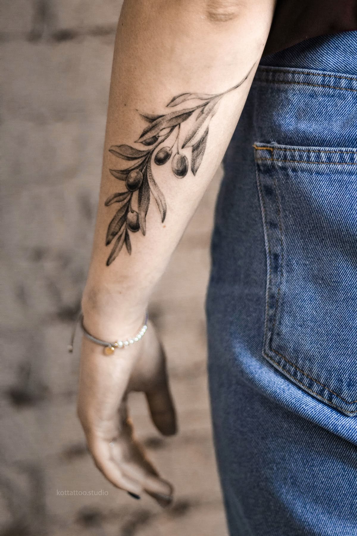 Flowing Black and Gray Olive Branch on the Arm, a tattoo design rendered in clean detailed linework.