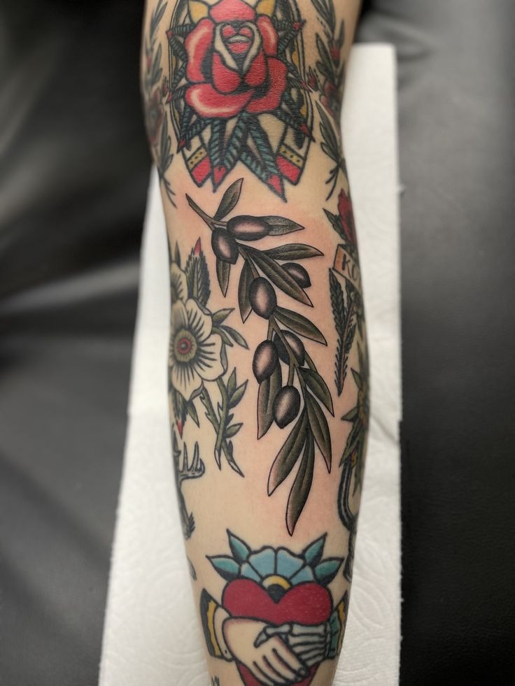 Olive Branch Added to an American Traditional Sleeve, a tattoo design rendered in minimalist fine-line for the arm.