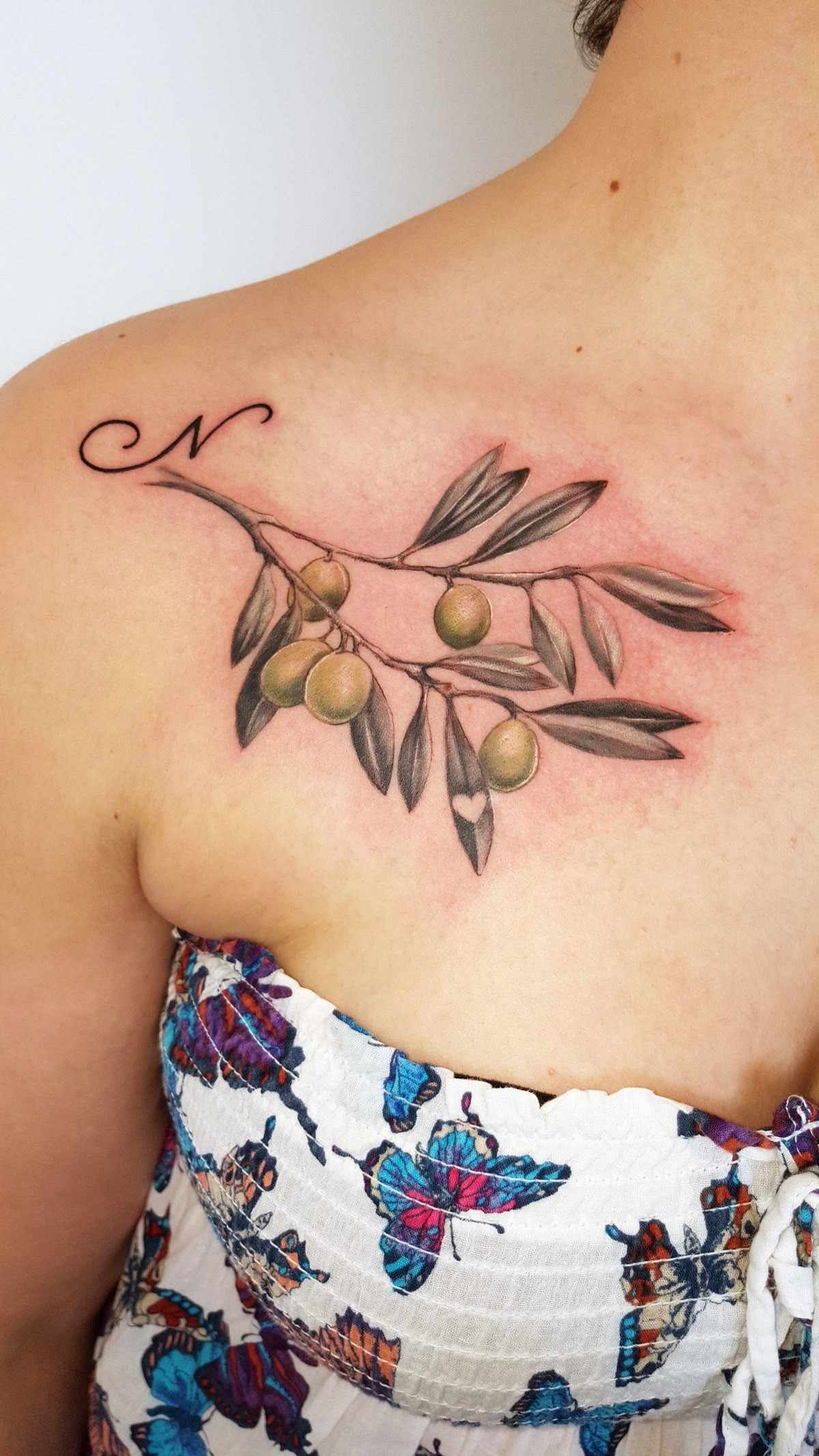 Olive Branch with Initial on the Shoulder, a tattoo design rendered in clean detailed linework.
