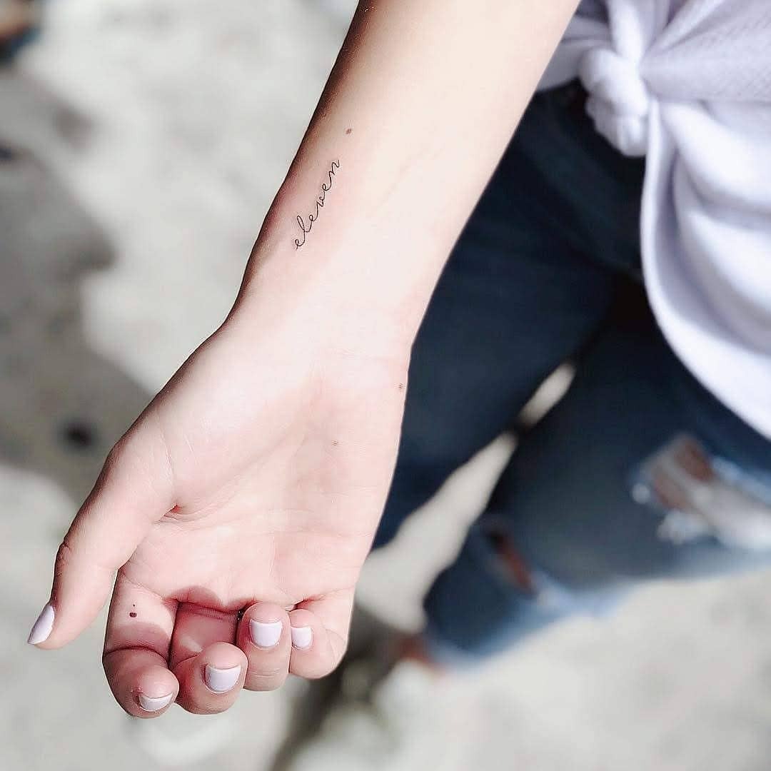 Minimalist tattoo featuring the word 'eleven' Tattoo Design