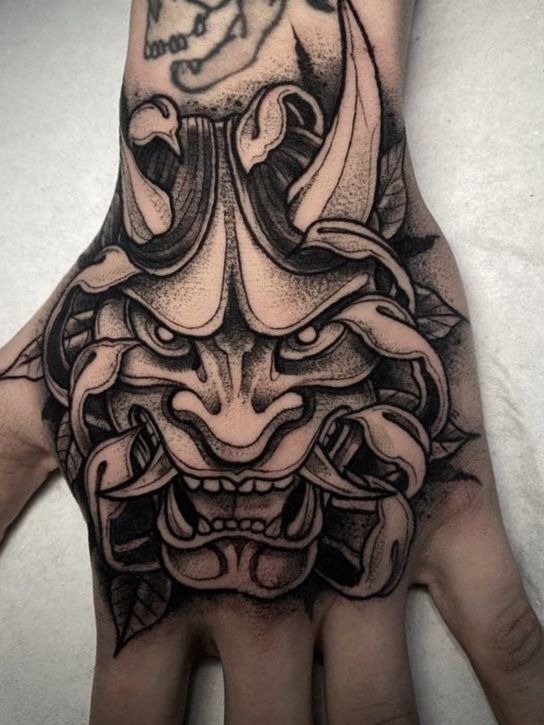 Fierce and floral at once, this hand tattoo is a perfect crossover between nature and demon.