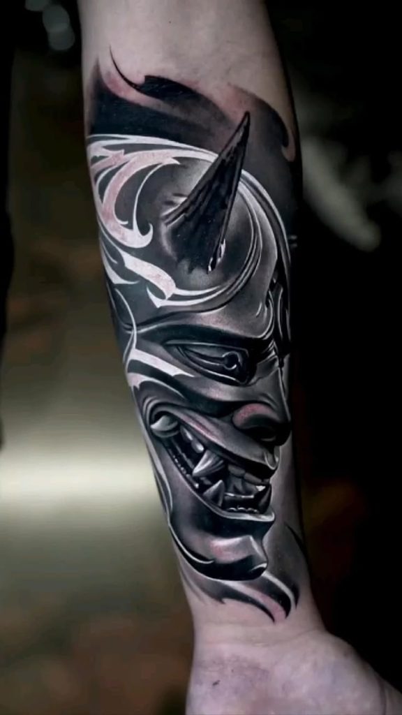 This dark and sleek forearm tattoo looks like it's made of chrome.