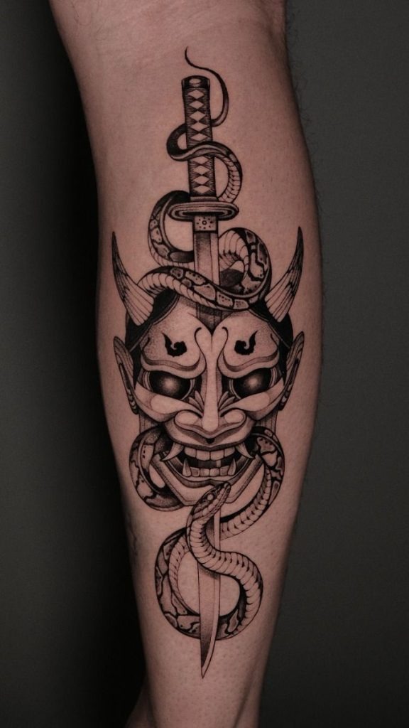This black-and-grey design features a stylized Japanese oni mask pierced by a traditional katana, tightly coiled by a snake.