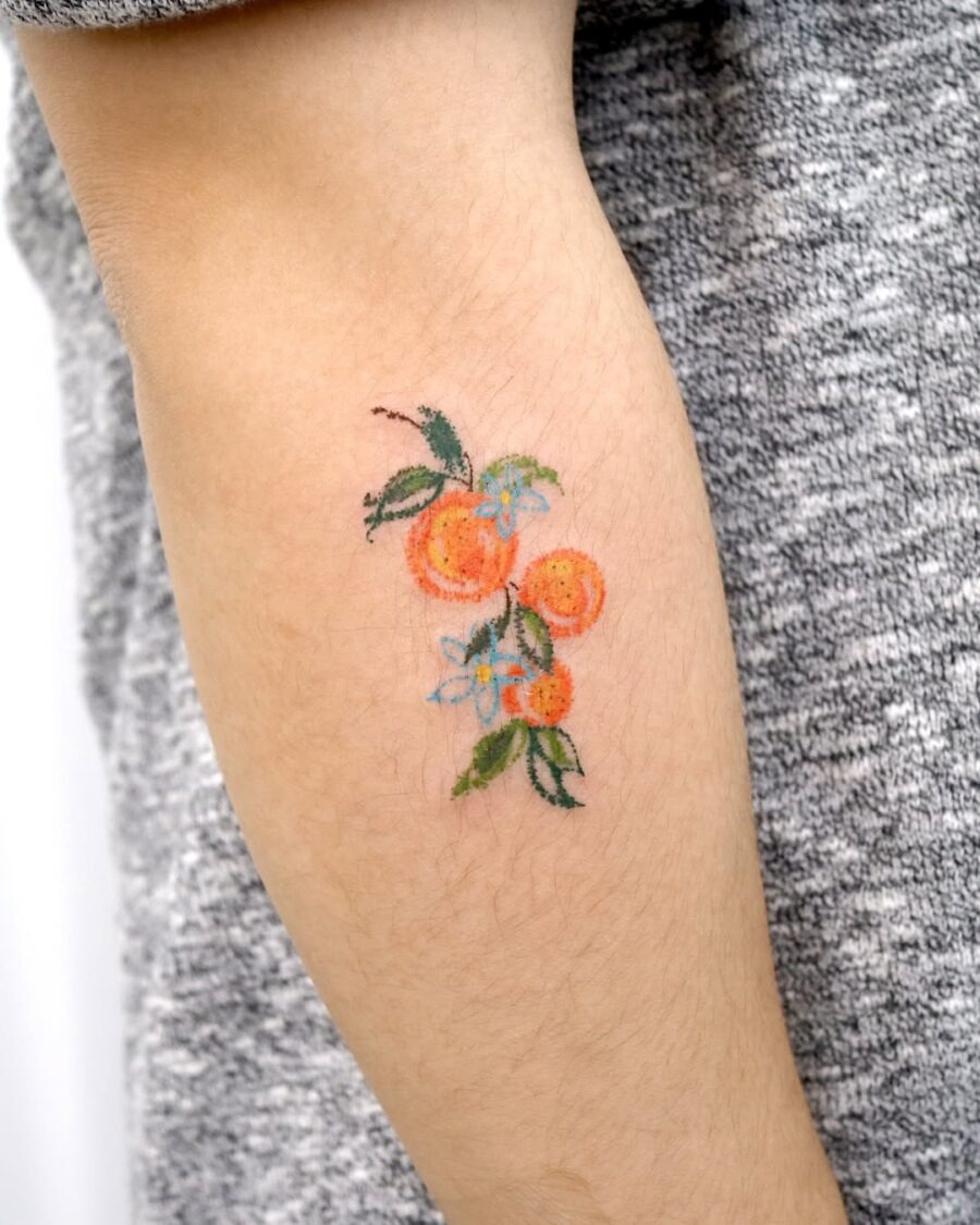 Vibrant orange fruit tattoo with floral accents Tattoo Design
