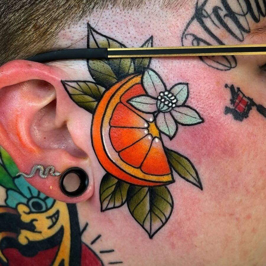 Vibrant orange tattoo with floral accents on skin. Tattoo Design