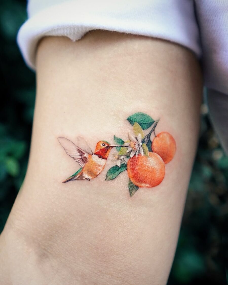 Vibrant tattoo featuring a hummingbird and oranges Tattoo Design