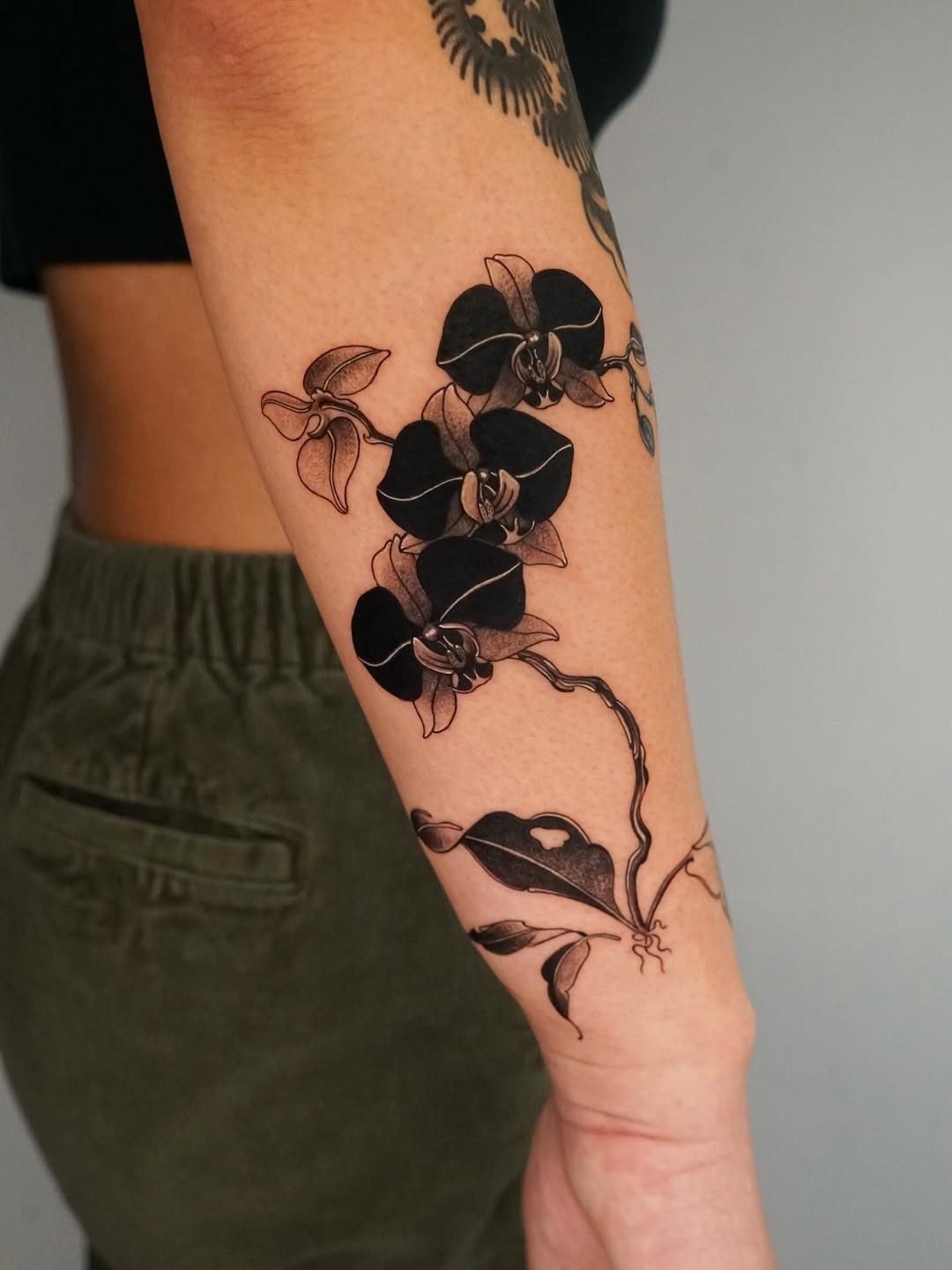 Elegant black orchid tattoo on forearm Tattoo Design