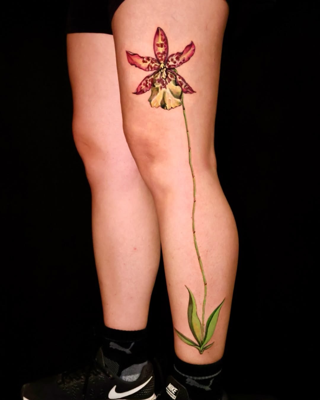 Stunning orchid tattoo gracing the leg Tattoo Design