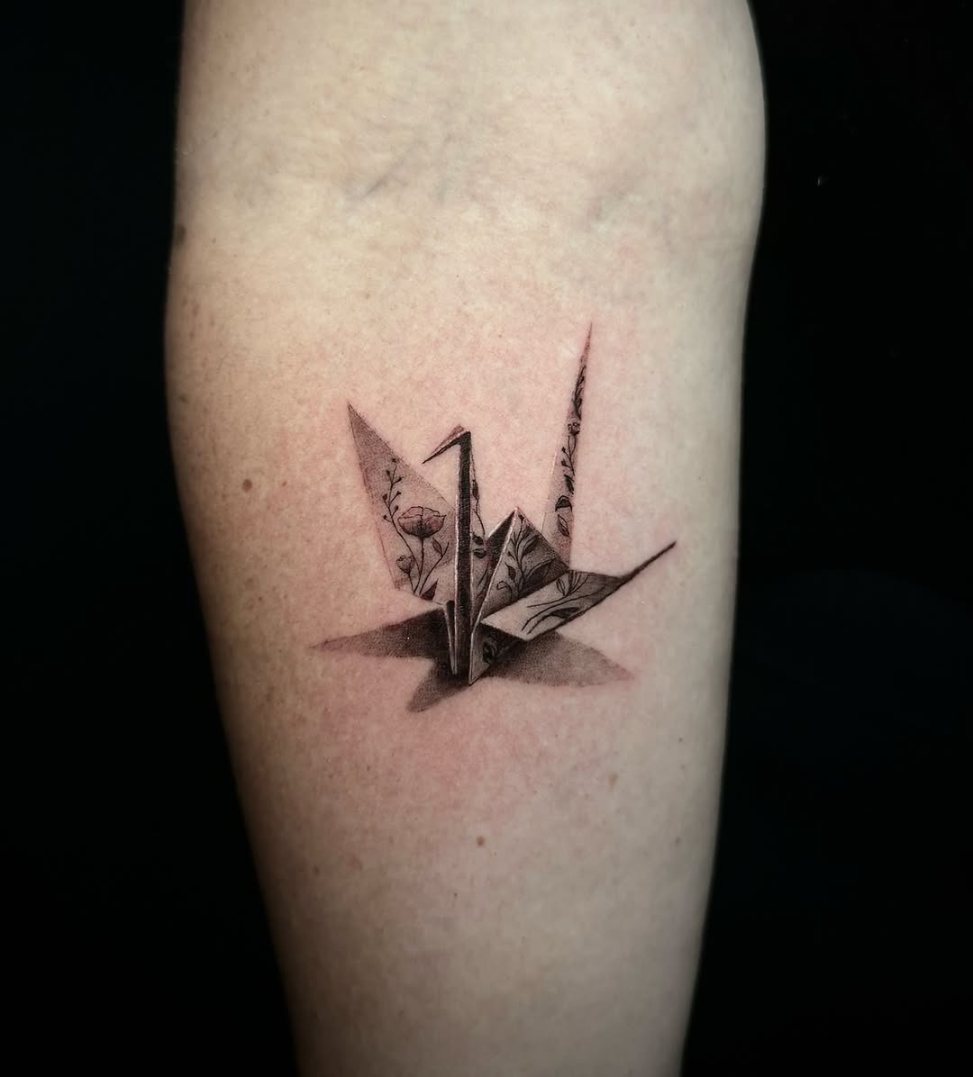 Elegant origami crane tattoo with floral details Tattoo Design