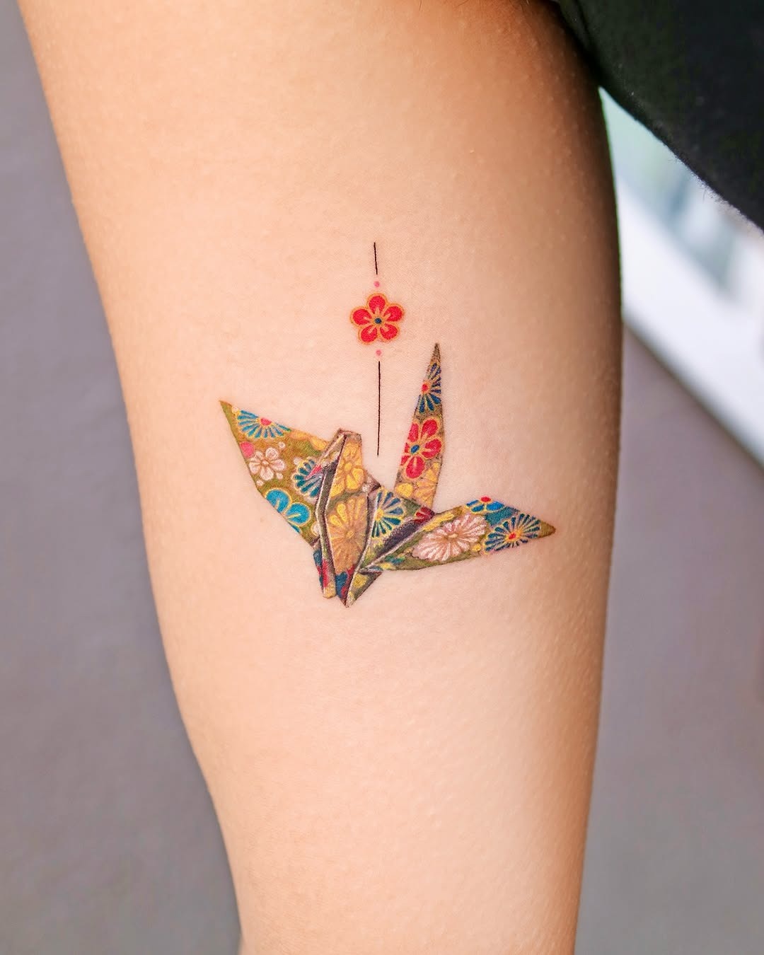 Vibrant origami crane tattoo with floral details Tattoo Design