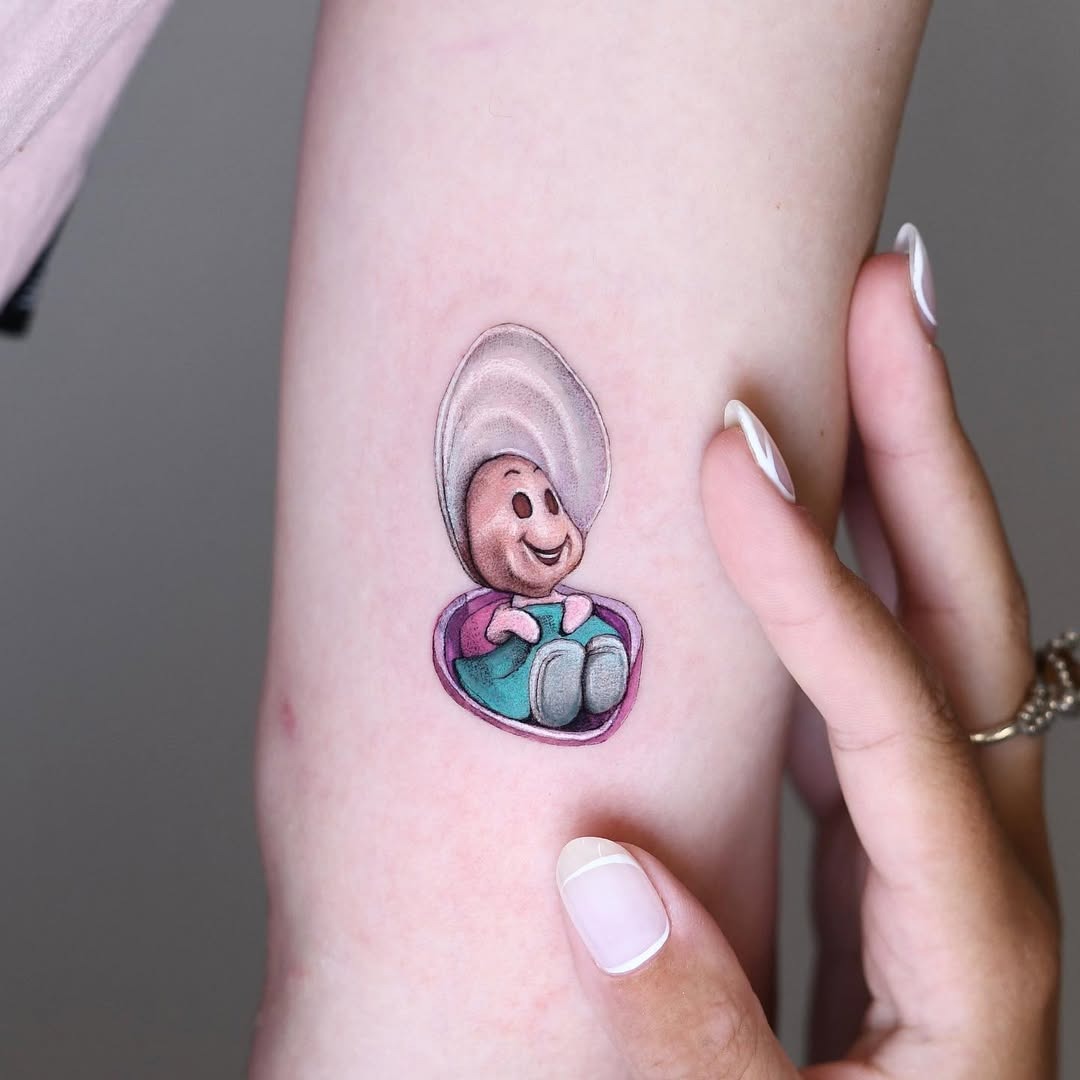 This tattoo features a delightful cartoon oyster, complete with a cheerful smile and playful colors.