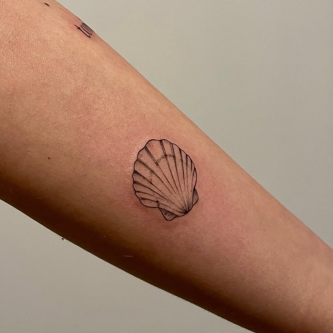 This tattoo showcases a beautifully detailed oyster shell etched in fine lines.