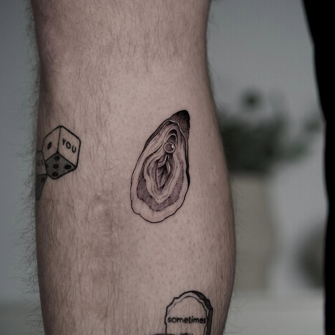 This tattoo showcases a beautifully detailed oyster, capturing its unique shape and texture.