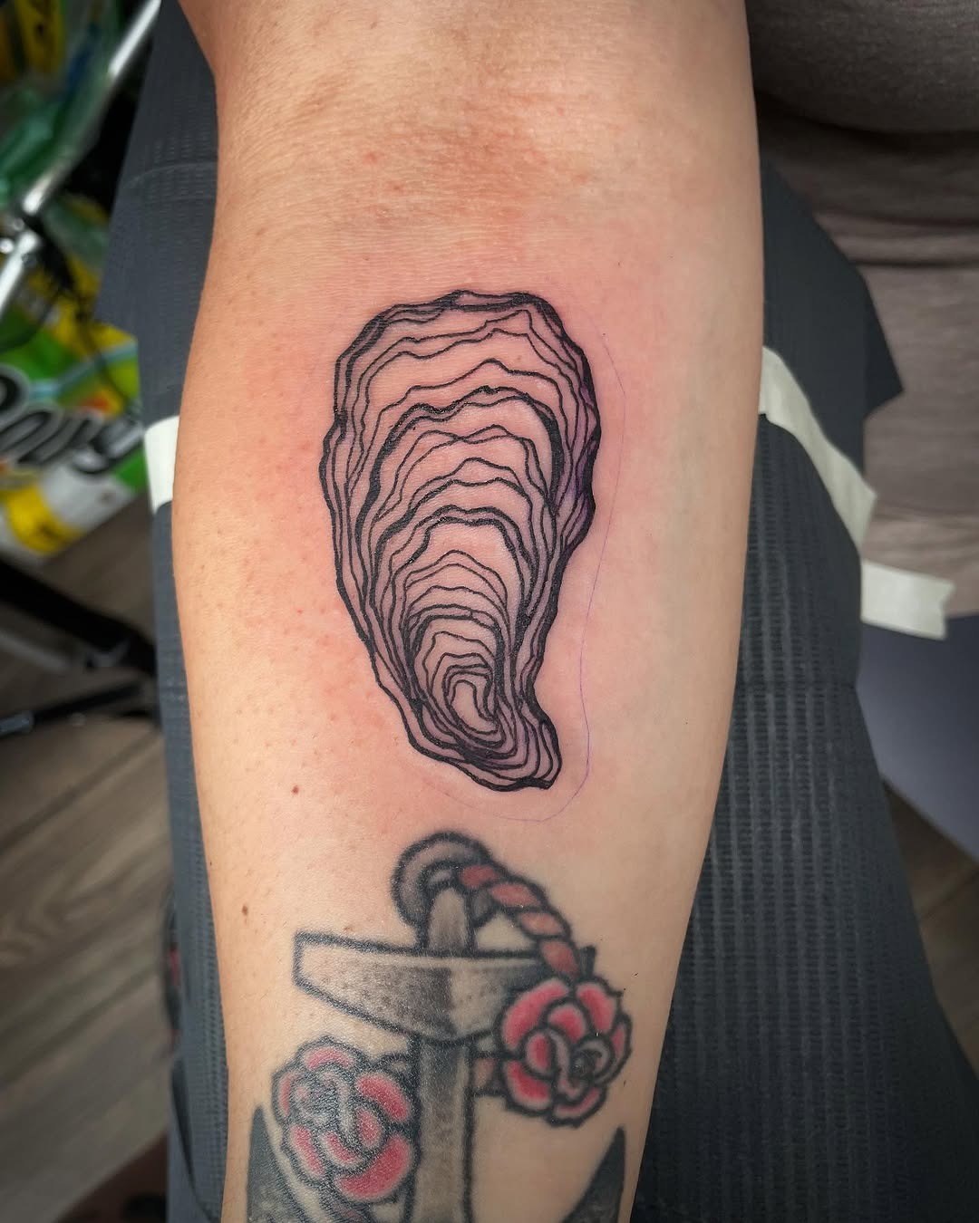 This oyster tattoo features intricate line art, creating a minimalist yet striking appearance.