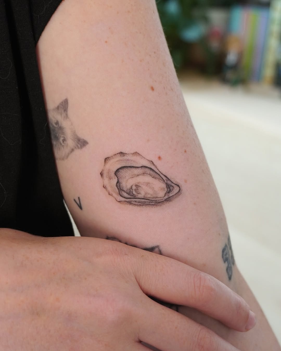 This tattoo features a beautifully realistic oyster design on the arm.