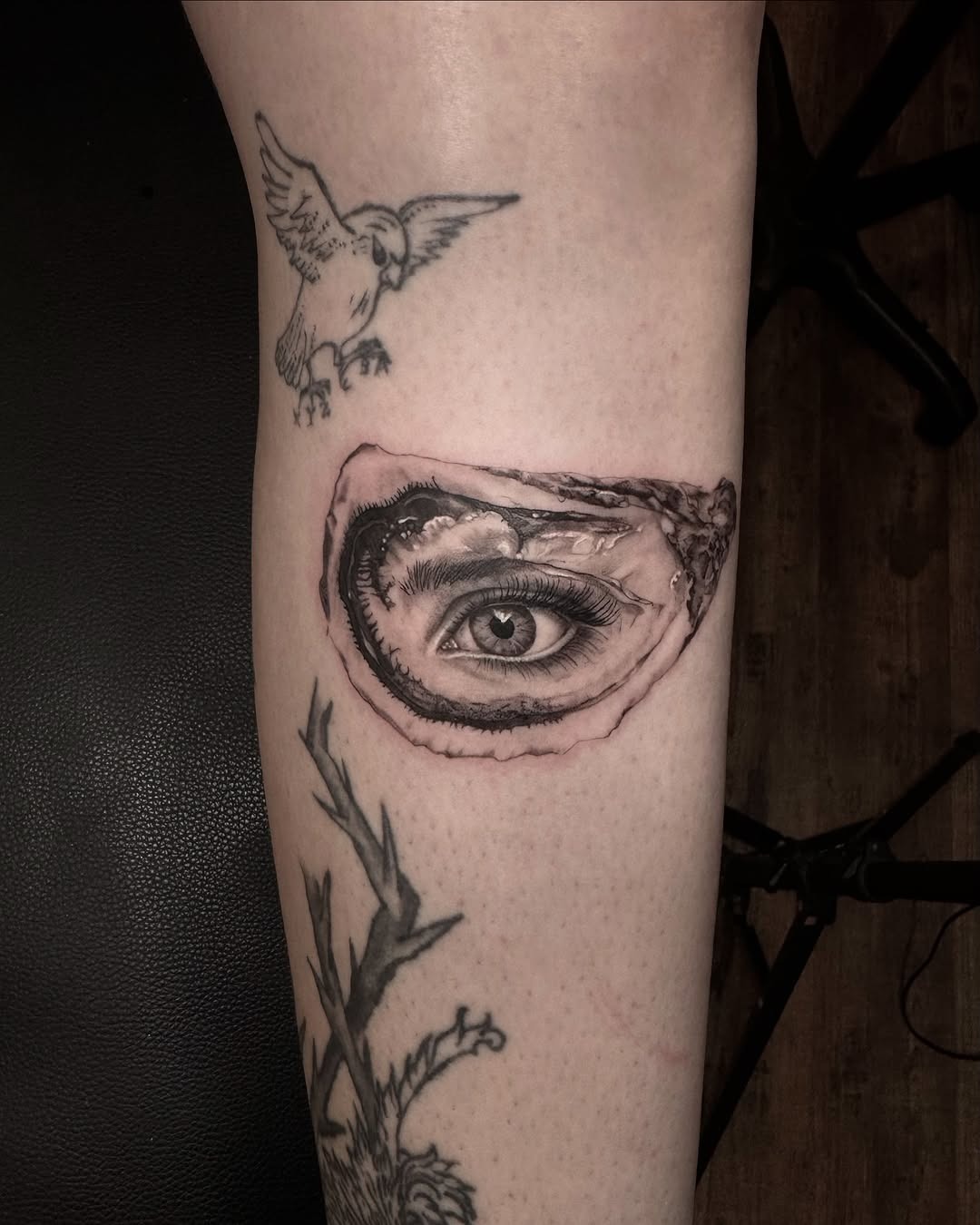 This stunning oyster tattoo reveals a mesmerizing eye, captivating and mysterious.