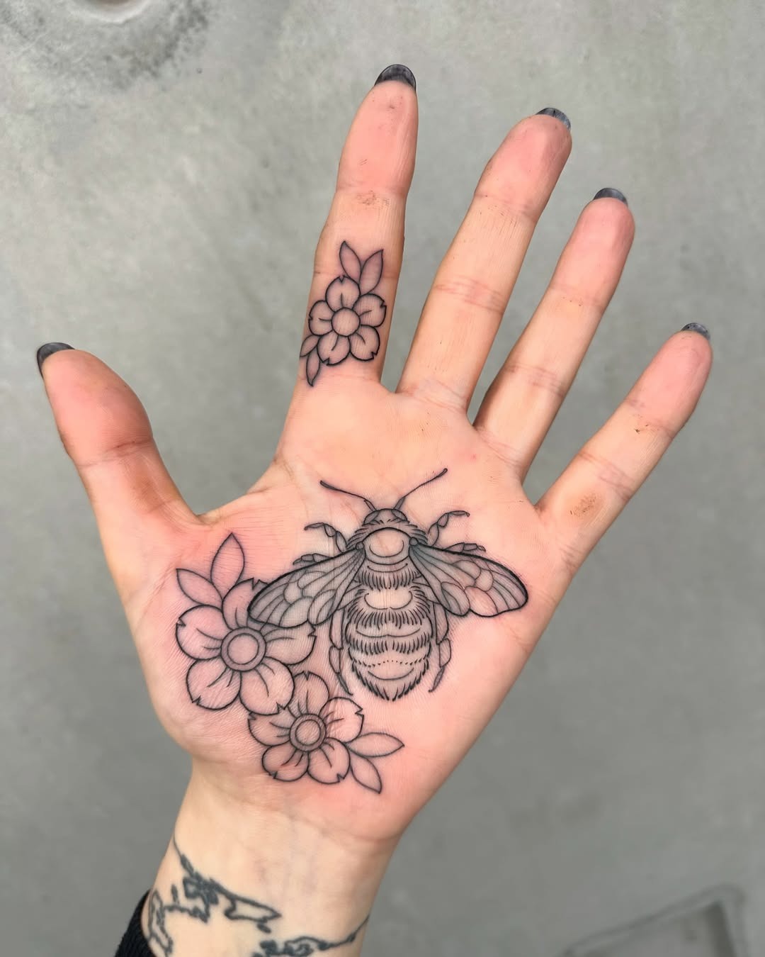 Intricate palm tattoo featuring bee and flowers Tattoo Design
