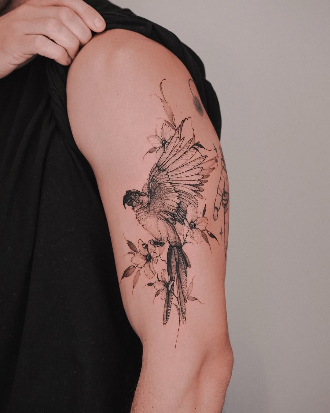 Intricate parrot tattoo with floral accents Tattoo Design