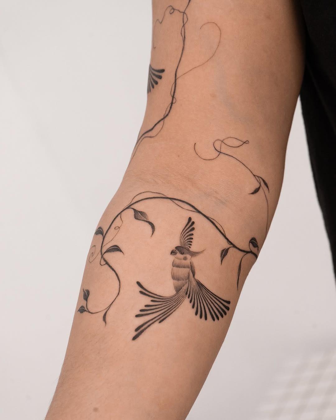 Stylish parrot tattoo with vine accents Tattoo Design
