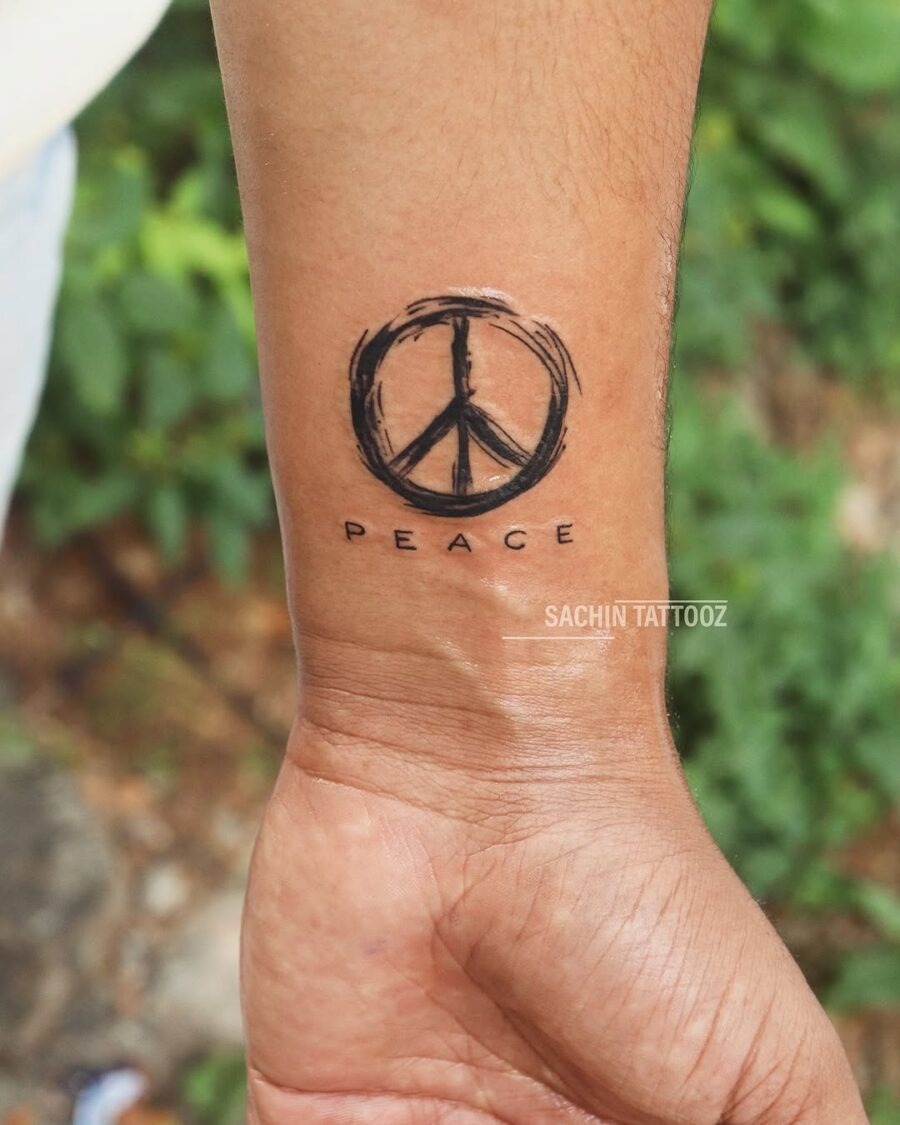 Minimalist peace symbol tattoo on wrist Tattoo Design