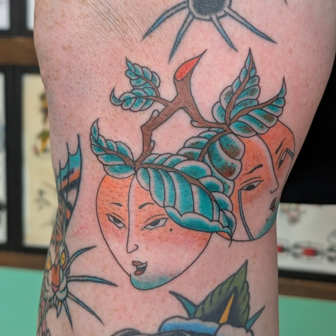 Artistic peach tattoo with whimsical faces. Tattoo Design