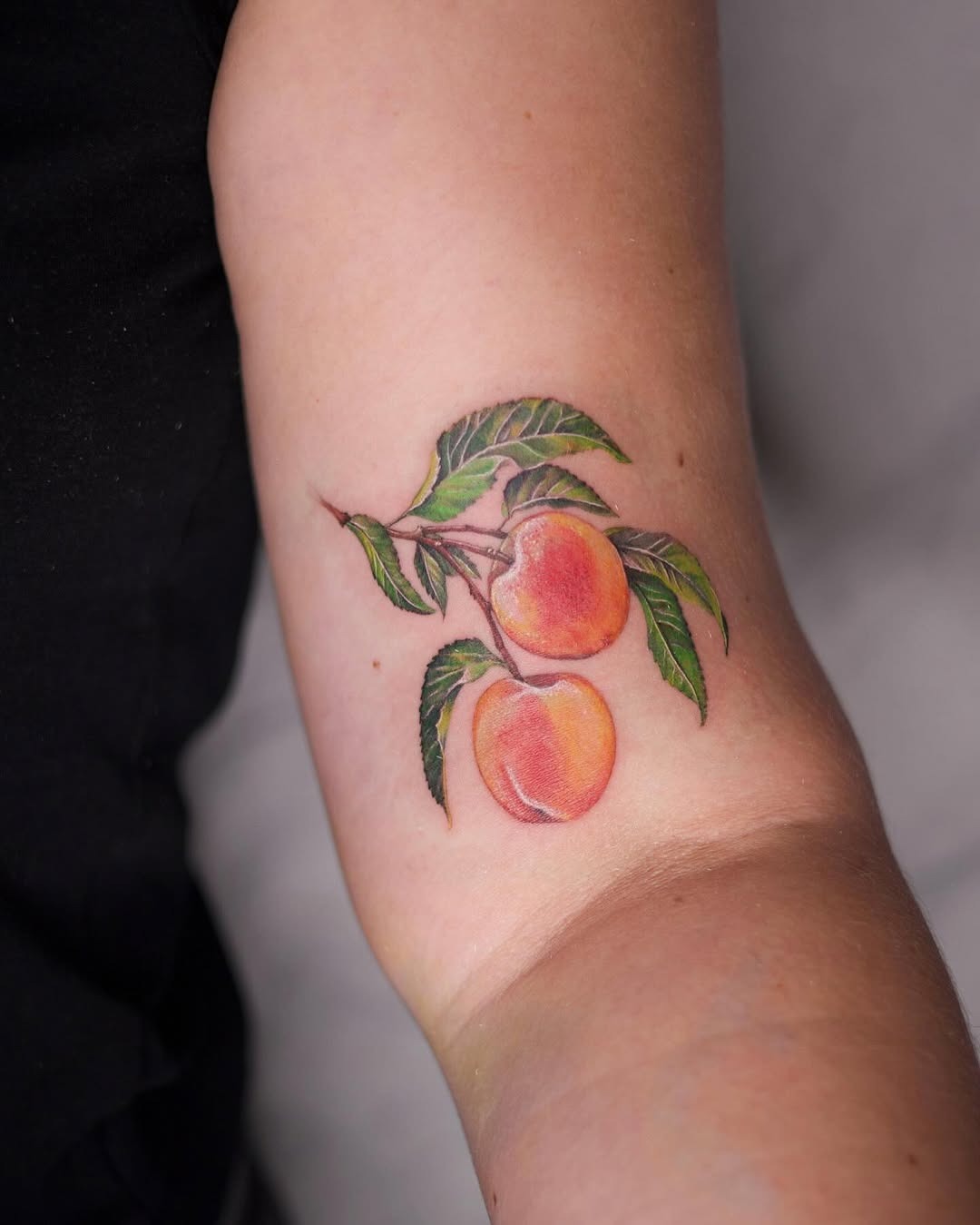 Colorful peach tattoo with lush green leaves Tattoo Design
